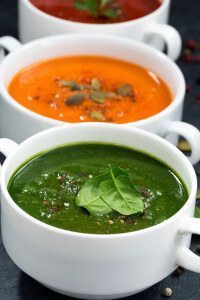 assortment of fresh vegetable cream soup on a black background,